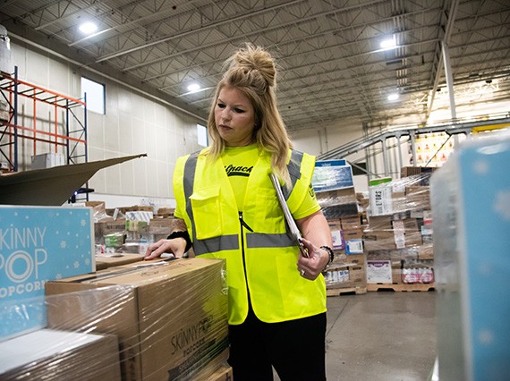 Food safety associate reviewing boxes in warehouse